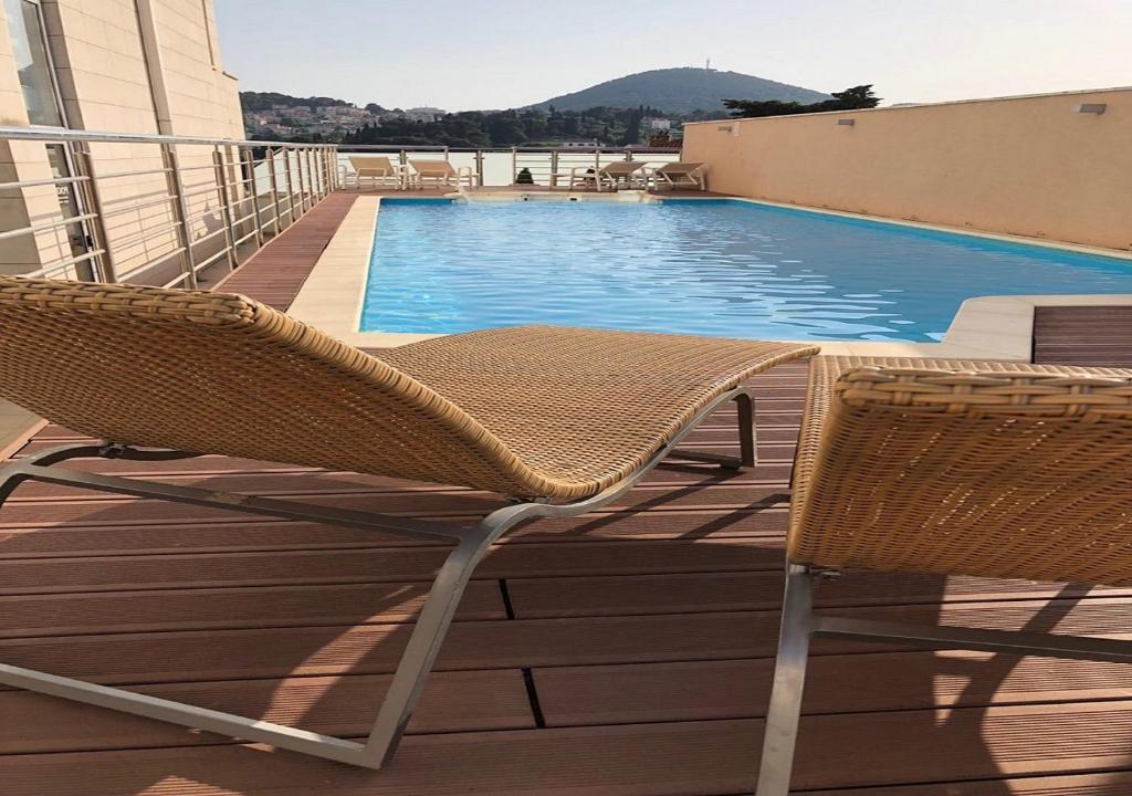 a pair of chairs sitting next to a swimming pool at Berkeley Hotel & Day Spa in Dubrovnik