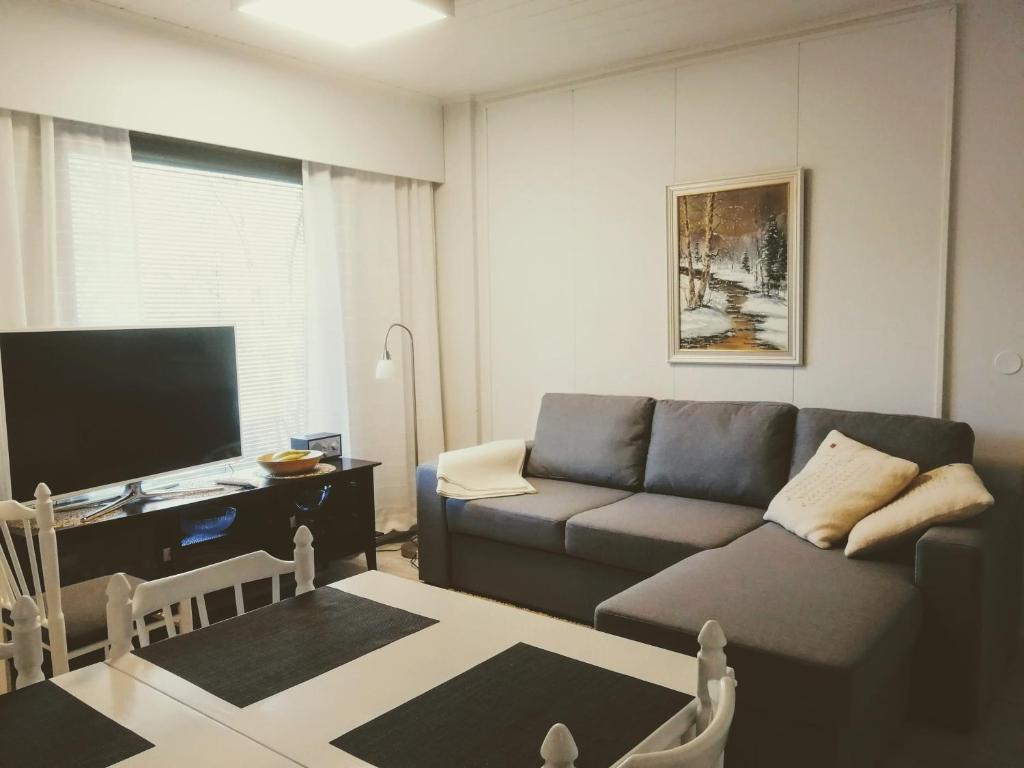 sala de estar con sofá y mesa en Huoneisto Villa Kaitera, en Kuusamo