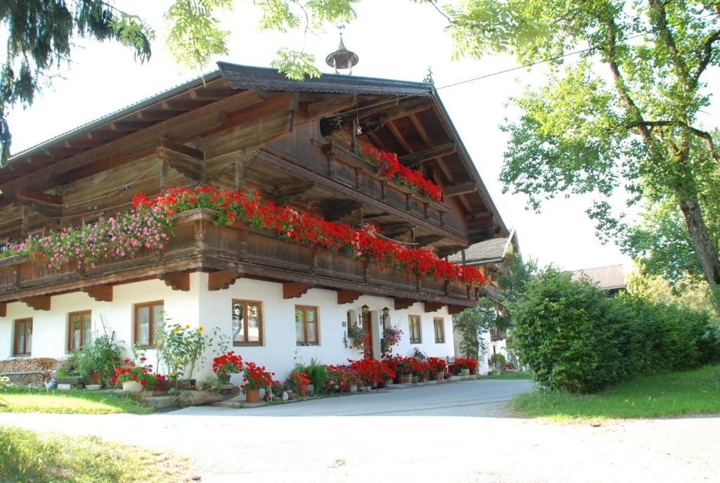 un edificio con flores rojas a un lado. en Bacherhof, en Söll