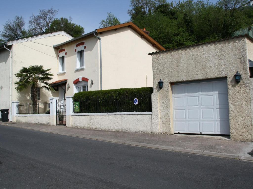 una casa blanca con dos puertas de garaje en una calle en Gîte Belleville-sur-Meuse, 4 pièces, 4 personnes - FR-1-585-42 en Belleville-sur-Meuse