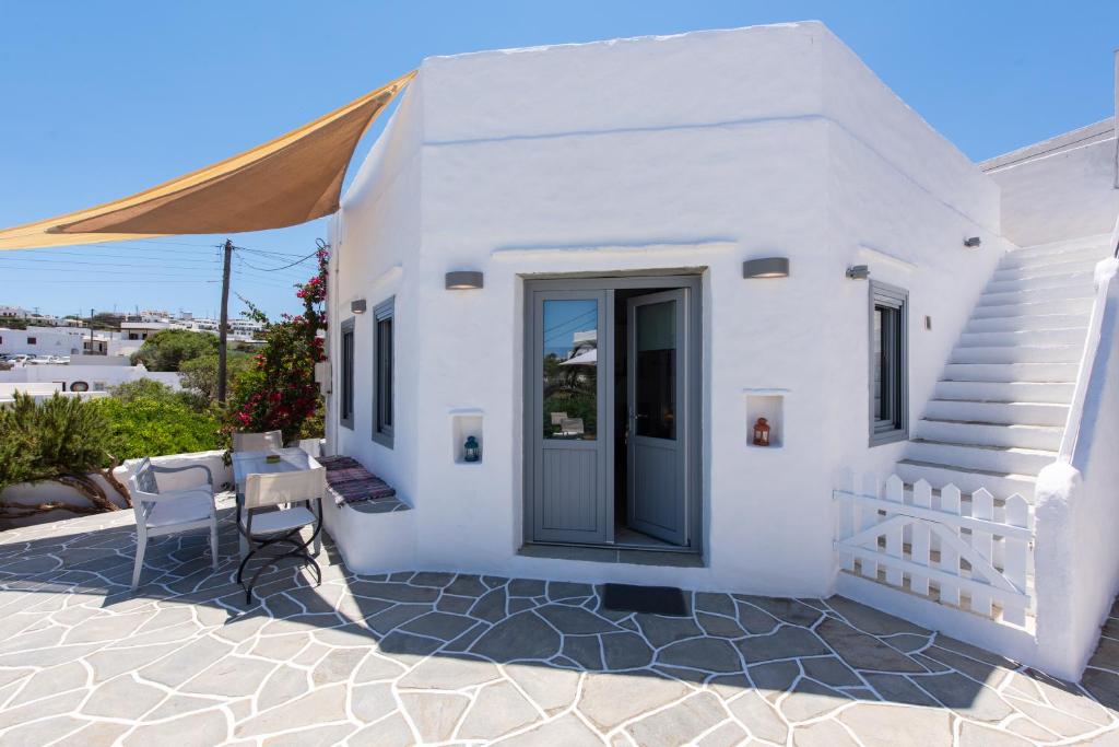 een wit huis met een tafel en stoelen bij Dora's traditional houses in Apollonia