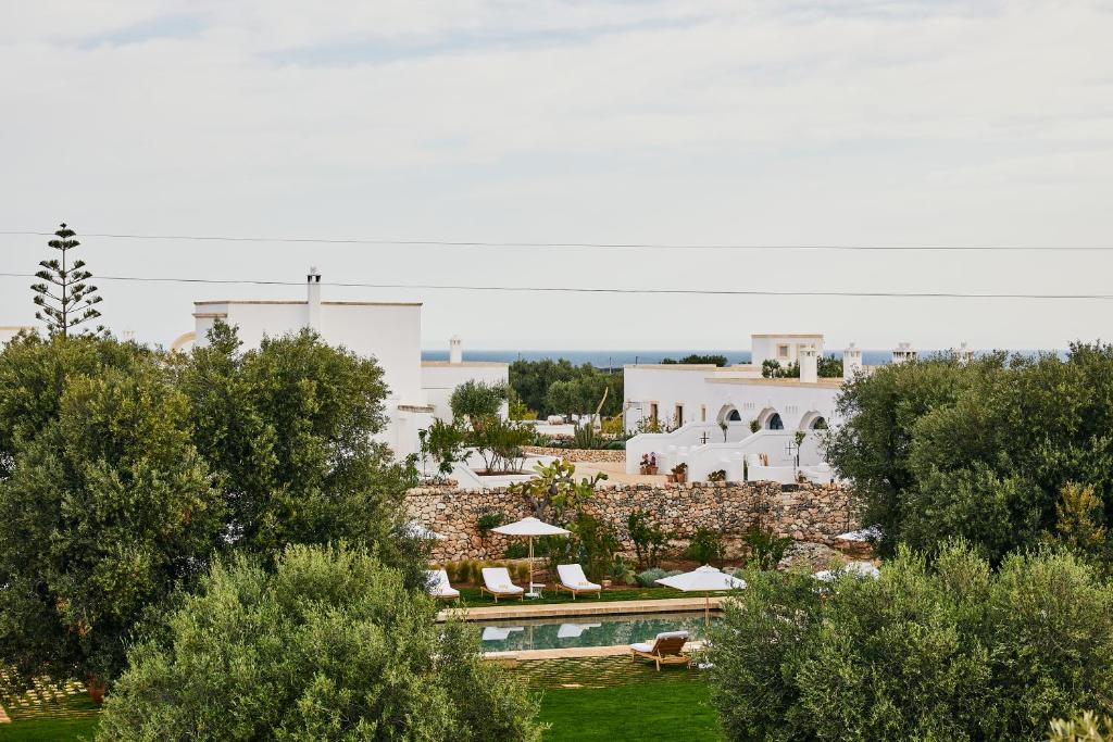 uma vista para um resort com uma piscina e árvores em Masseria Calderisi em Savelletri di Fasano