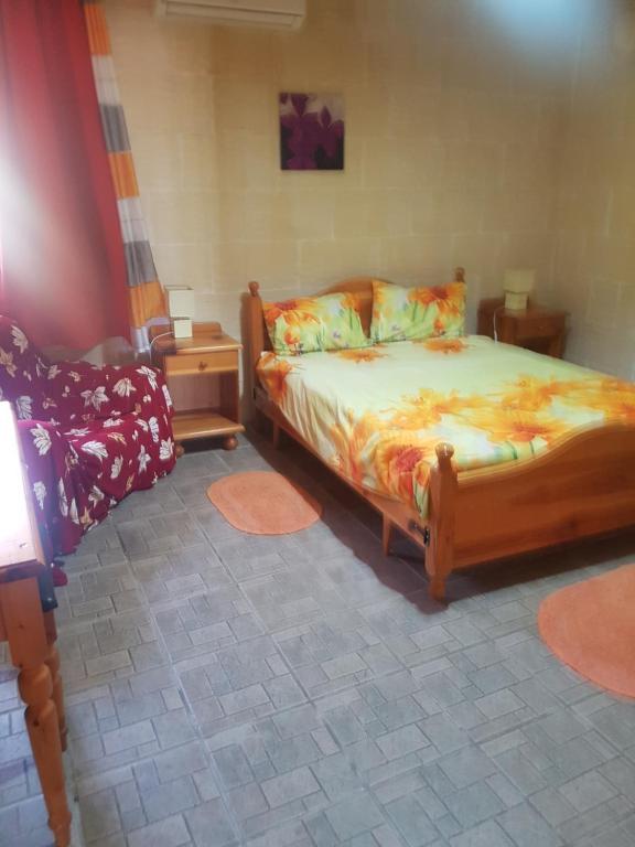 ein Schlafzimmer mit einem Bett und zwei Nachttischen und einem Bett sidx sidx sidx in der Unterkunft Ta' Karkar Villa Bed and Breakfast in Xagħra