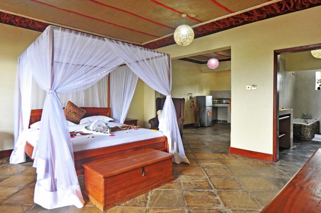 a bedroom with a bed with a canopy at Mwanzo Lodge in Naivasha