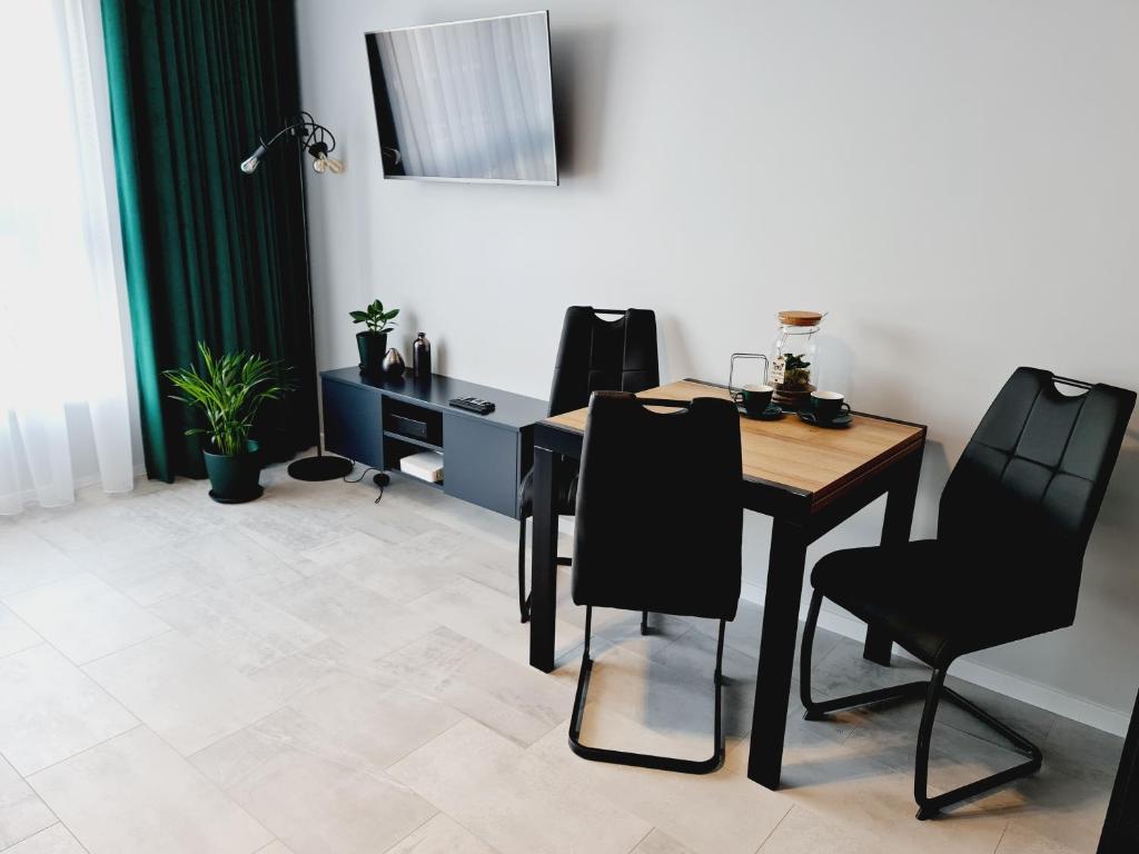 une salle à manger avec une table et des chaises noires dans l'établissement Apartament Wałowa, à Gdańsk