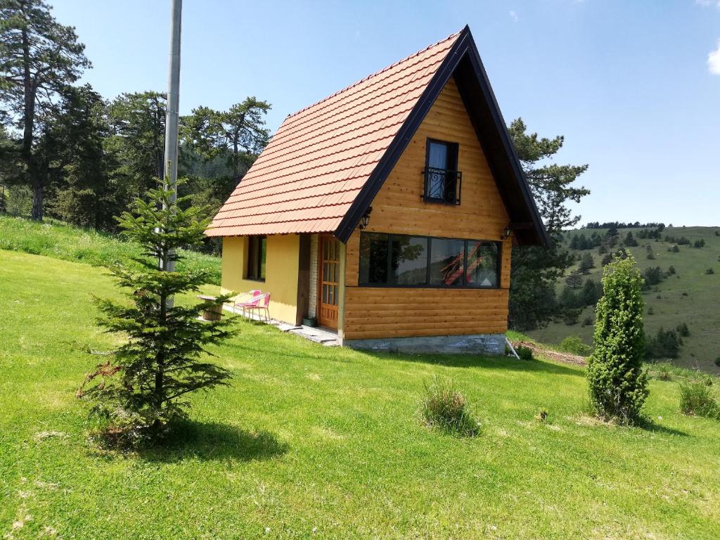 ein kleines Haus auf einem Feld mit einem Baum in der Unterkunft Kod Gruja in Ribnica