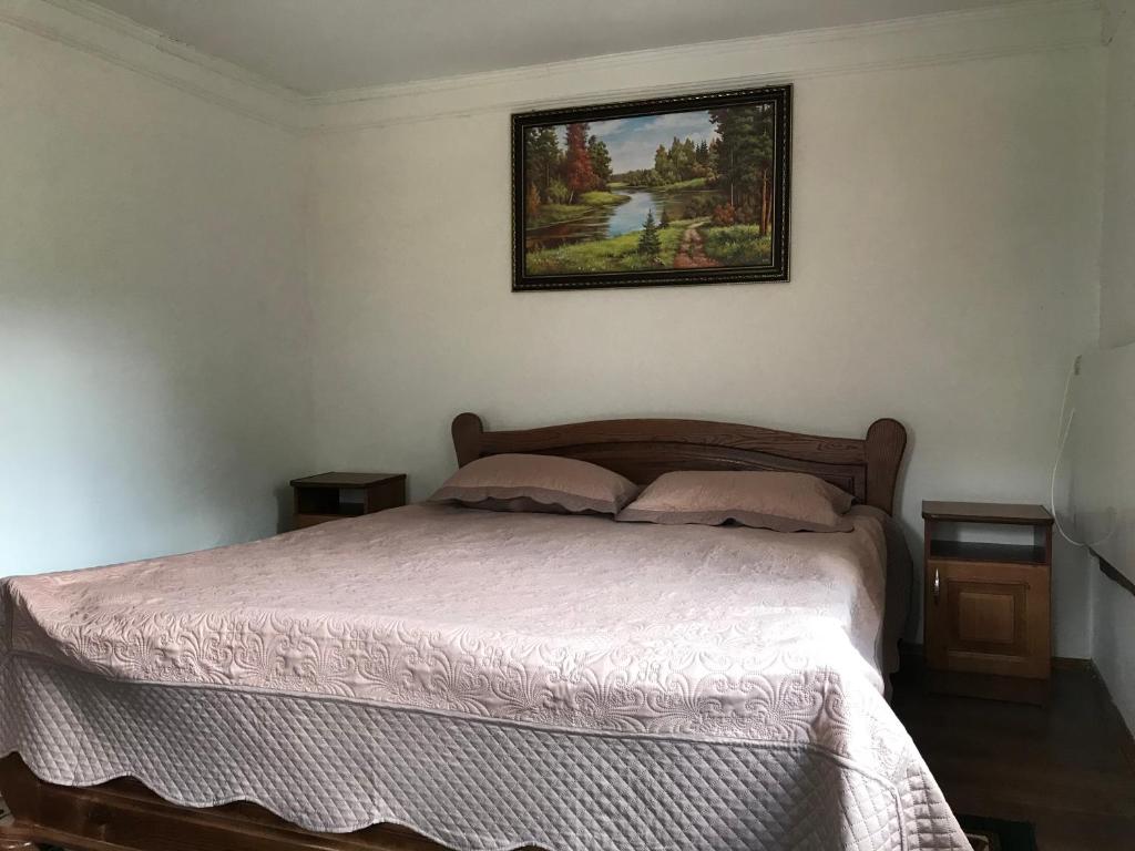 uma cama num quarto com uma fotografia na parede em Підскельний em Yaremche