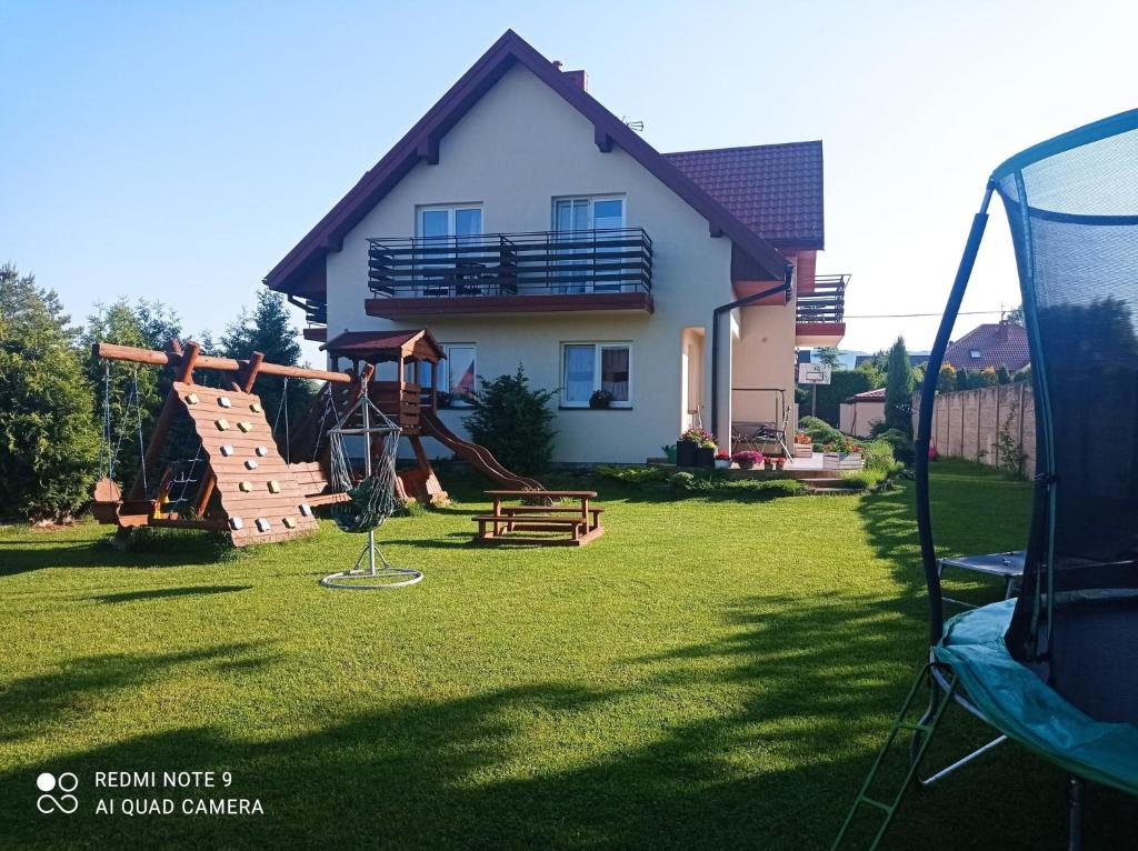 un patio con parque infantil y una casa en Oaza Świętokrzyska, en Wola Kopcowa