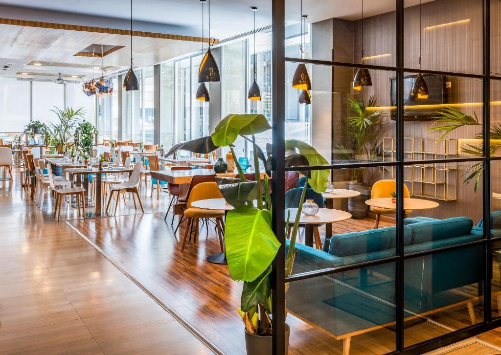 a restaurant with tables and chairs and plants at Hotel Madrid Chamartín, Affiliated by Meliá in Madrid