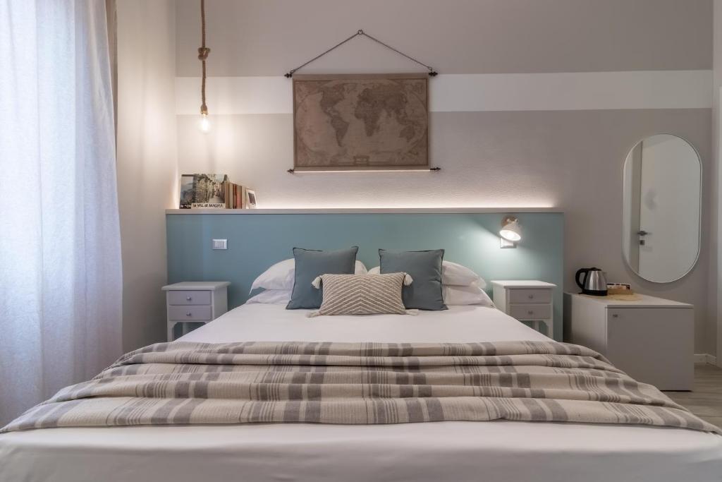 拉斯佩齊亞的住宿－阿克瑪麗娜旅館，一间卧室配有一张大床和蓝色床头板