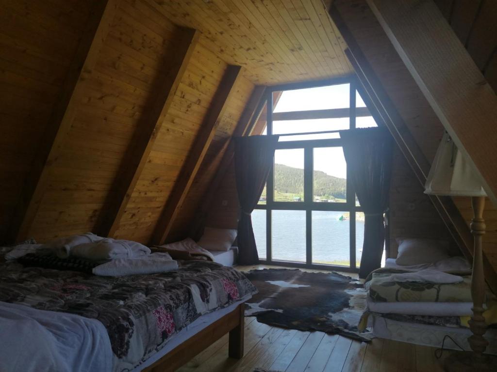 een zolderkamer met een bed en een raam bij Vikendica Ines in Nova Varoš
