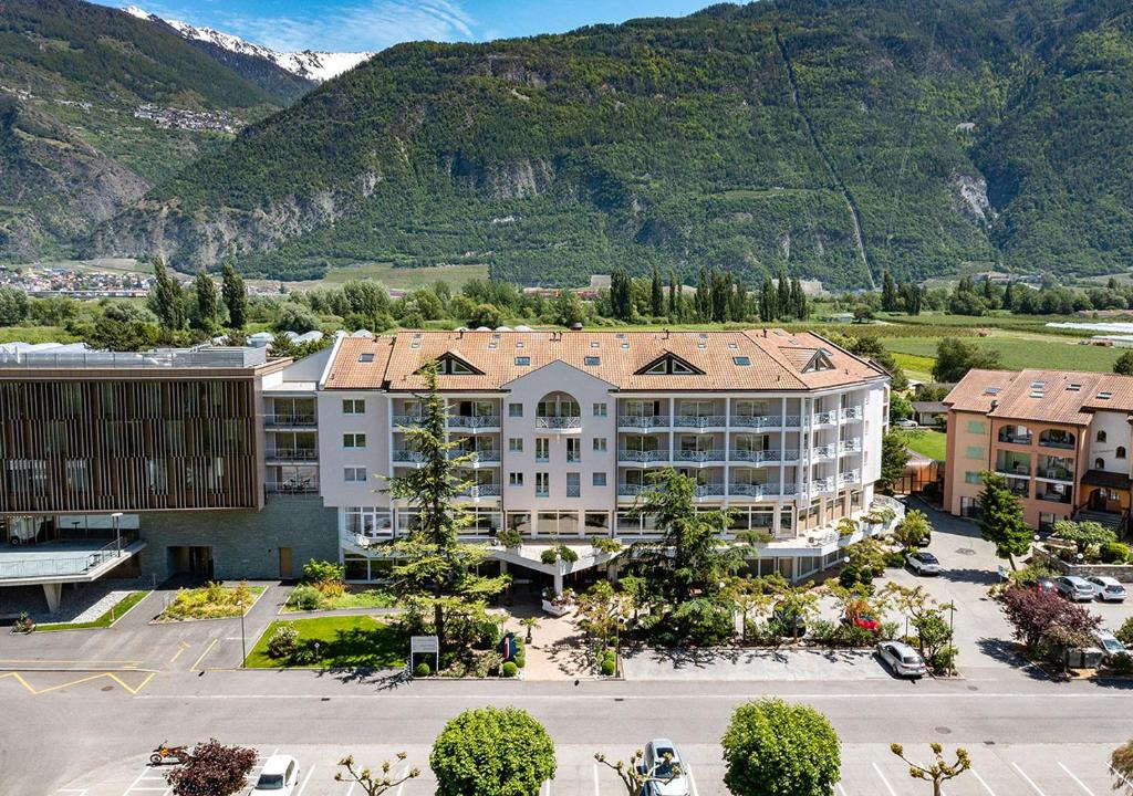une vue aérienne sur un hôtel avec des montagnes en arrière-plan dans l'établissement Hotel Farinet, à Saillon