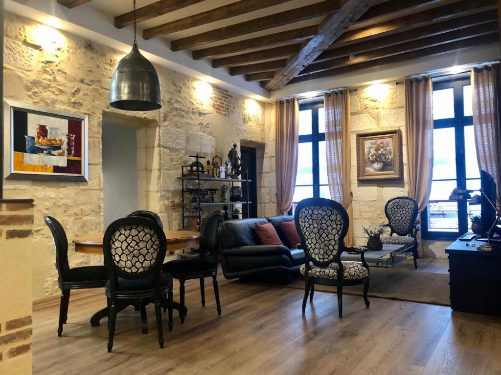 a living room with a couch and a table and chairs at le repère du marché in Bergerac