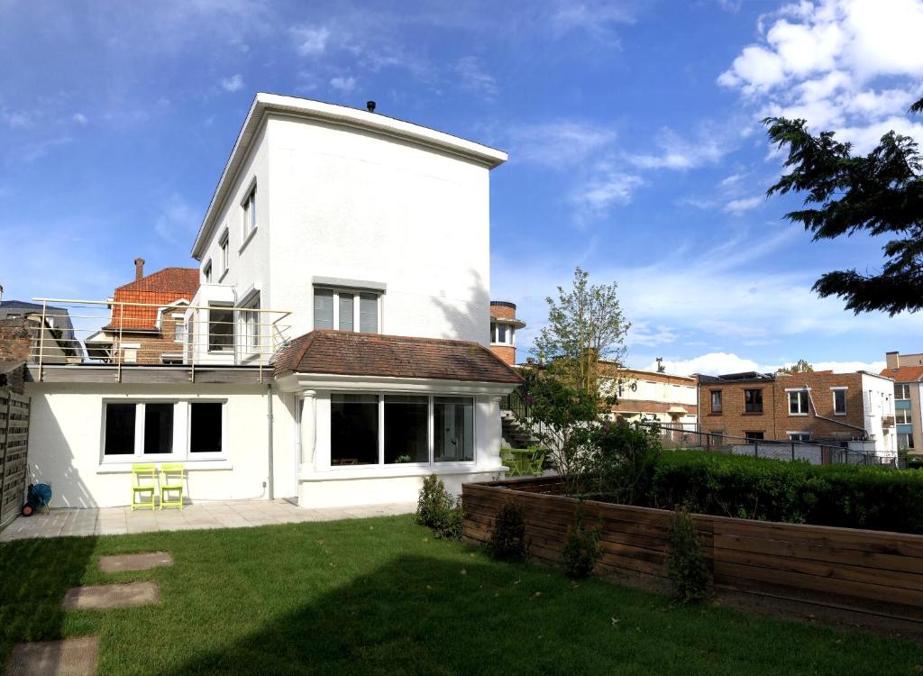ein weißes Haus mit einem Hof davor in der Unterkunft Appartement - Vakantiehuis Manou in De Panne