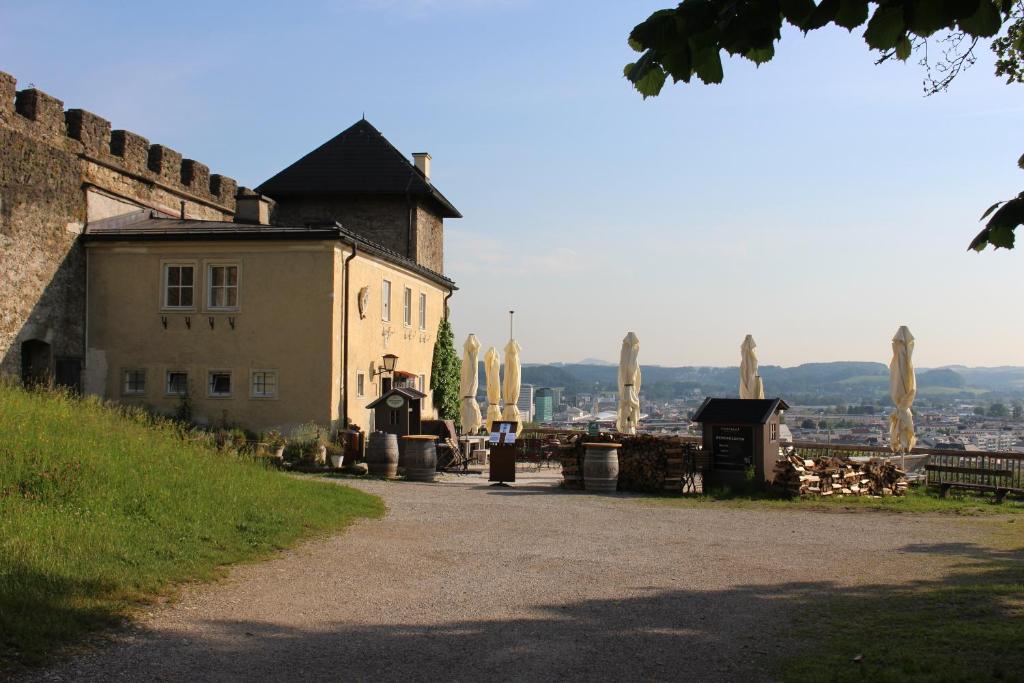 um edifício com algumas estátuas ao lado de uma estrada em Stadtalm Naturfreundehaus em Salzburgo