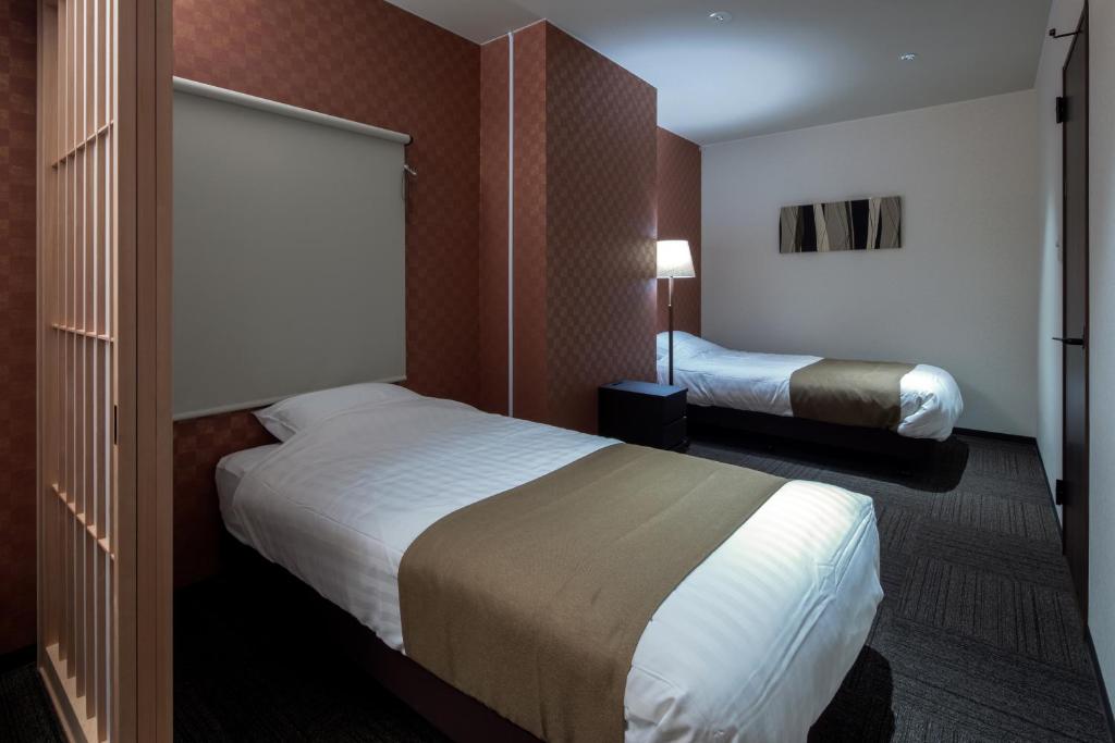 Postel nebo postele na pokoji v ubytování Randor Residence Hiroshima Suites