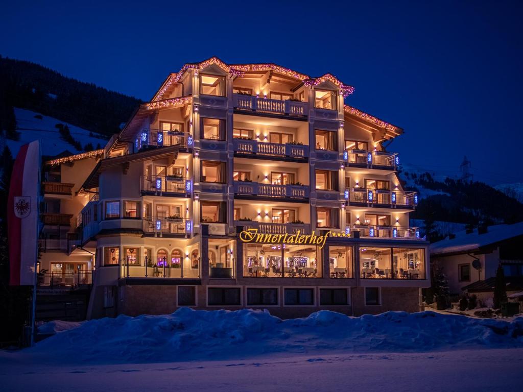 a large building with a sign on it at night at Wohlfühlhotel Innertalerhof in Gerlos