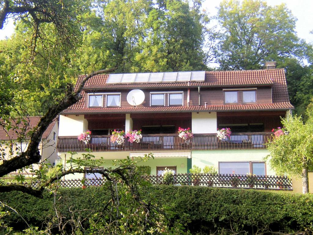 a building with a balcony with flowers on it at Gaestehaus Grau in Egloffstein