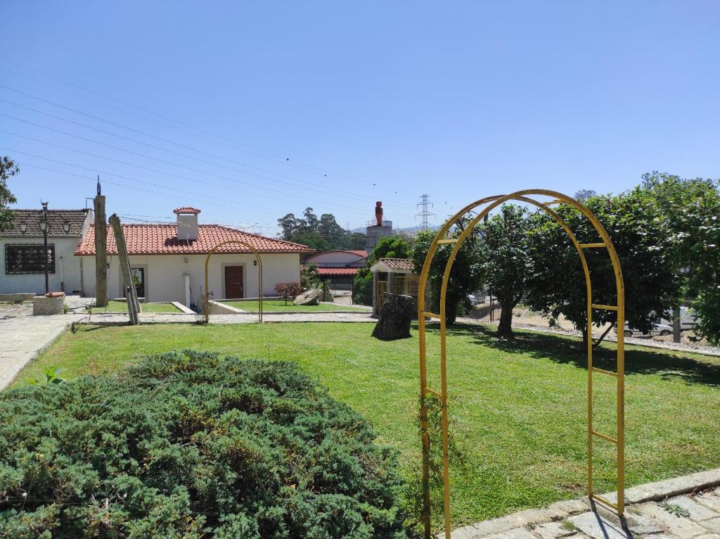 a gold gate in a yard with a house at Quinta do Gestal - Soutelo in Vila Verde