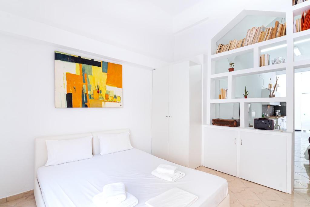 een witte slaapkamer met een wit bed en witte planken bij Aiolos Suite in Sitia