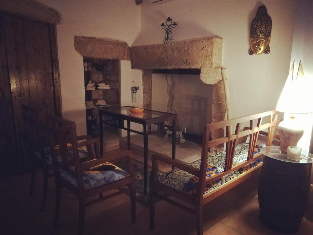 アッリステにあるZen Guest House Olisticaのリビングルーム(暖炉、テーブル、椅子付)