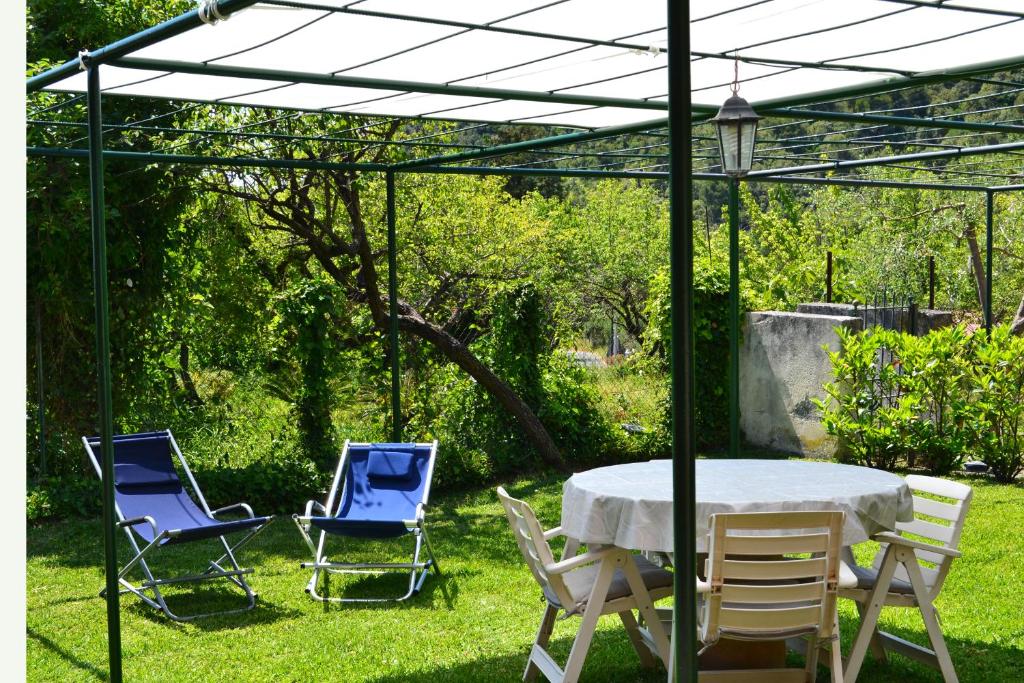 a table and chairs under a canopy in a yard at Le case di Nina in Maratea