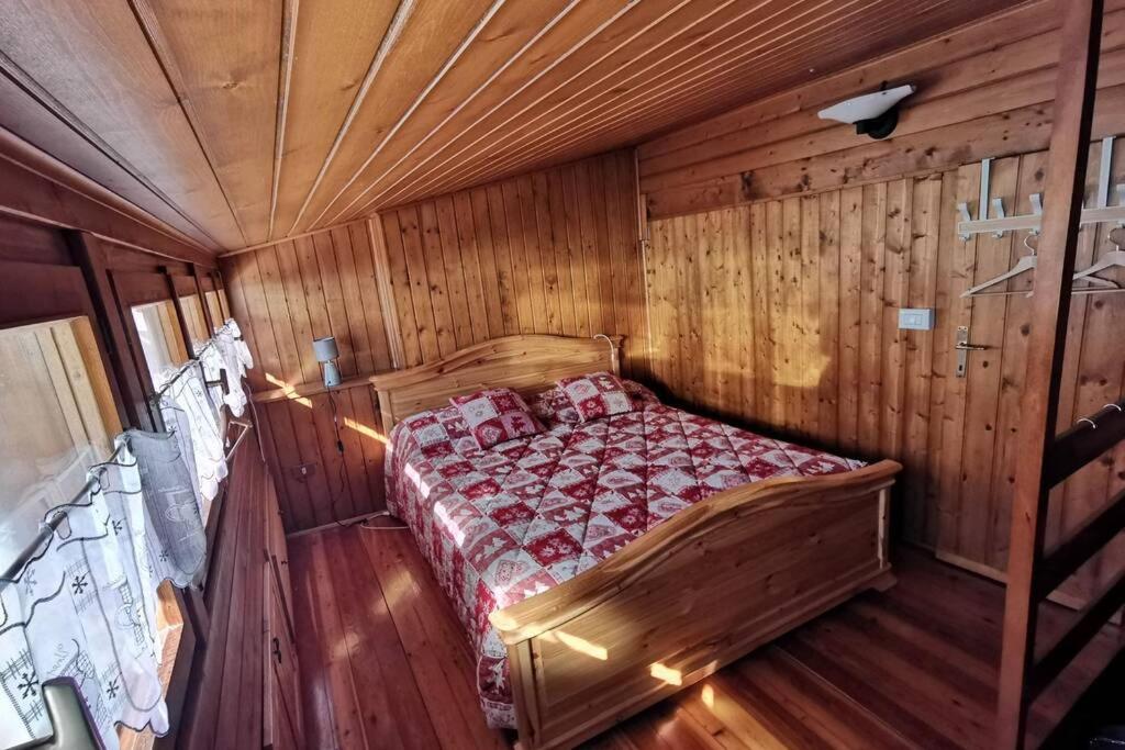 ein Schlafzimmer mit einem Bett in einem Holzzimmer in der Unterkunft Casa Bel Vedere in Falcade