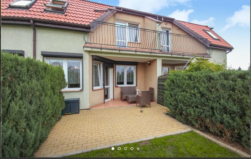 une maison avec une terrasse en face de celle-ci dans l'établissement Diament Darłowo, à Darłowo