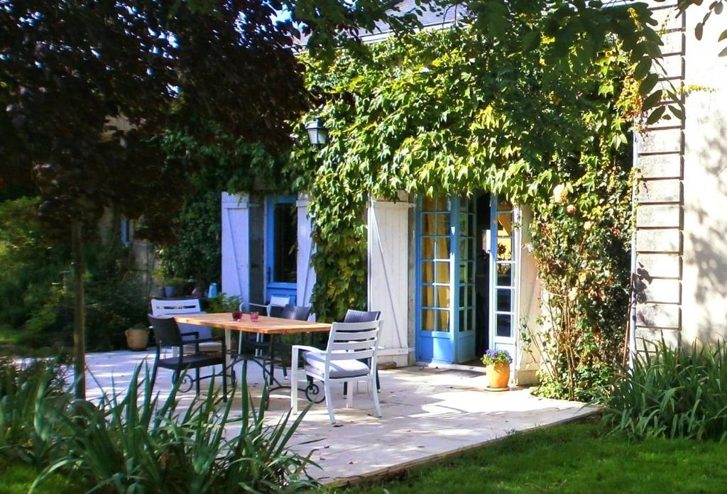 a patio with a table and chairs in front of a house at Loge & Broc in La Possonnière