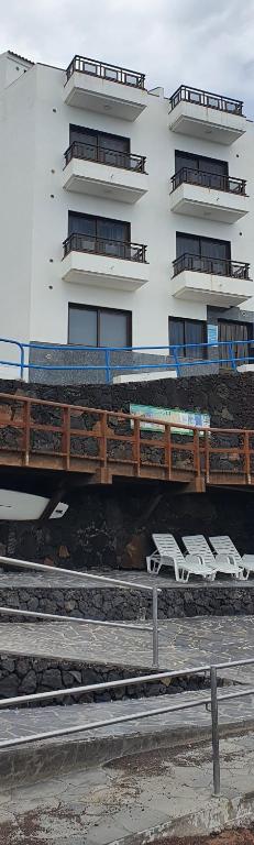 un edificio con un puente con sillas delante en LA MARINA III SEGUNDO A, en La Restinga