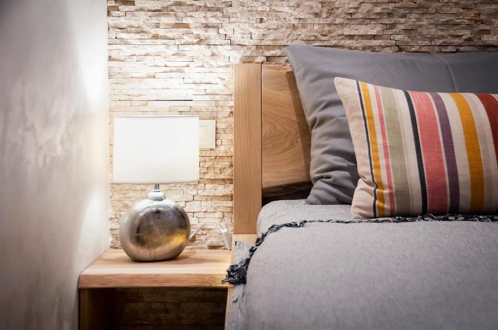 a bedroom with a bed and a lamp on a night stand at Ground Floor Gem (city centre) in Rovinj