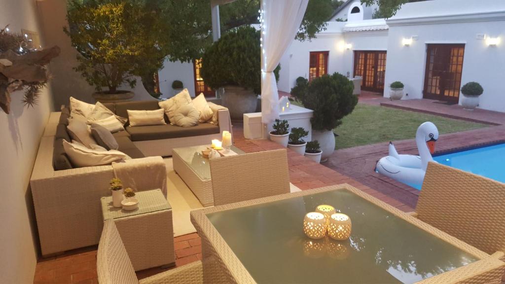 uma sala de estar com um sofá, uma mesa e uma piscina em Constantia Garden Suites em Cidade do Cabo