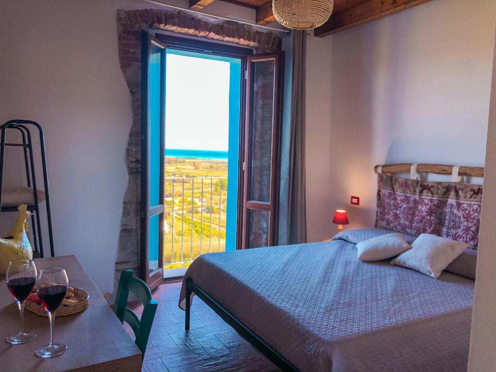 a bedroom with a bed and a window with a view at panoramic ROOMS Fora e ' Muros with sea view common terrace , Ammentos Posada in Posada