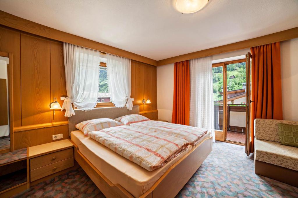 sypialnia z łóżkiem i dużym oknem w obiekcie Moosmair Ferienwohnung 1 w mieście San Martino