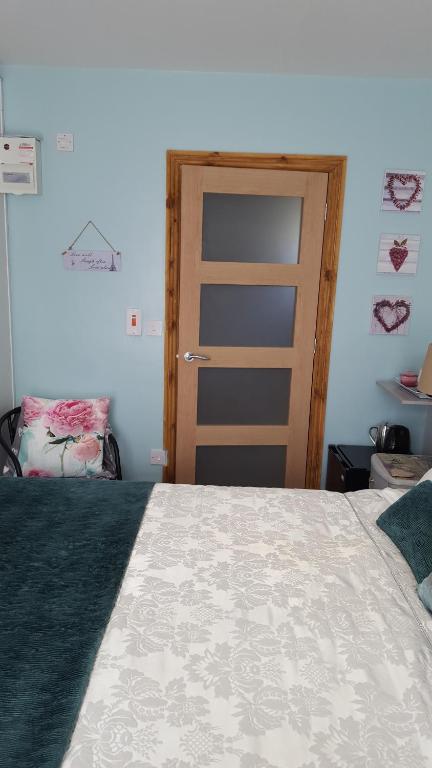 a bedroom with a large bed with a door at Lavenderescape. in Seahouses