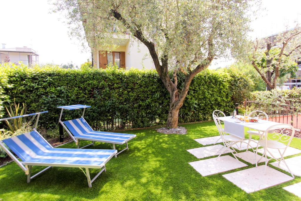 a yard with two chairs and a table and a tree at Maison Olive in Desenzano del Garda