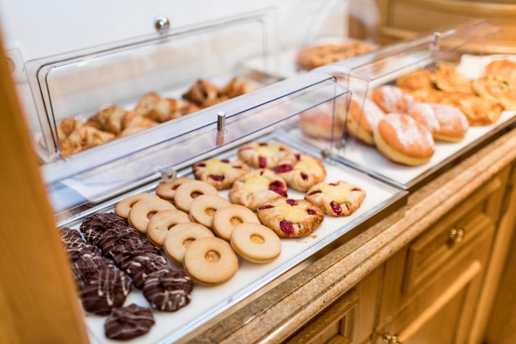 a display case filled with lots of different types of donuts at Hotel Genziana in Selva di Val Gardena