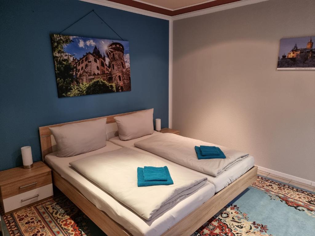 a bedroom with a large bed with blue walls at Ferienhaus Wernigerode "Am Schlossbühel" 5 Schlafzimmer in Wernigerode