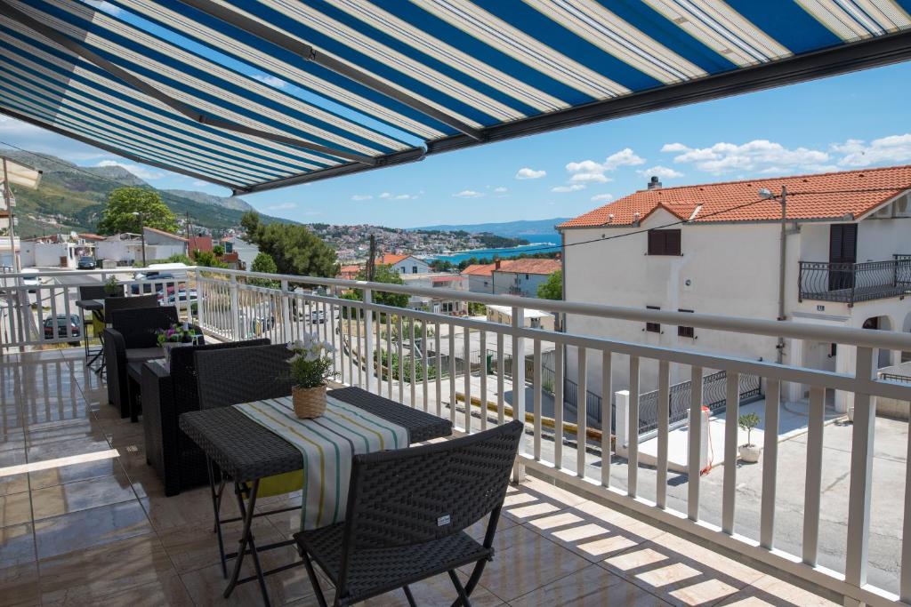 un patio con tavolo e sedie sul balcone. di Villa Lavanda Spalato a Kamen