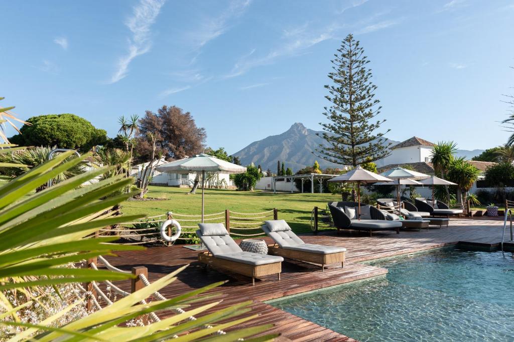 una piscina con un montón de tumbonas junto a un complejo en Boho Club, en Marbella