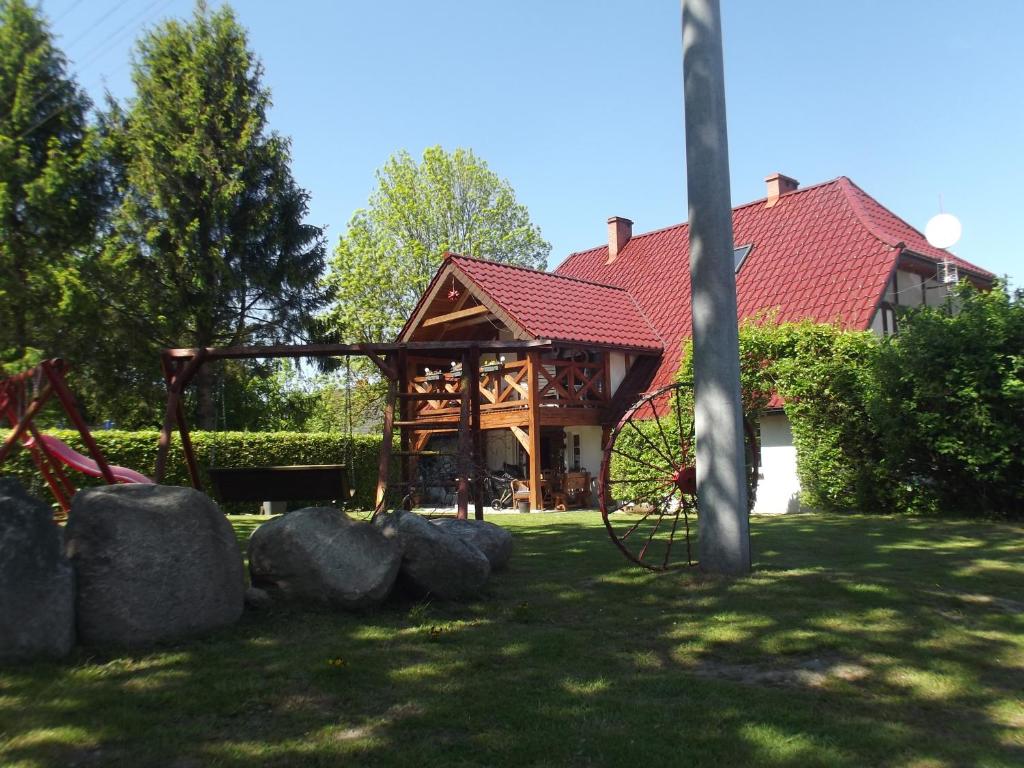 a house with a red roof and some rocks at Agroturystyka Bogusław X in Jezierzany