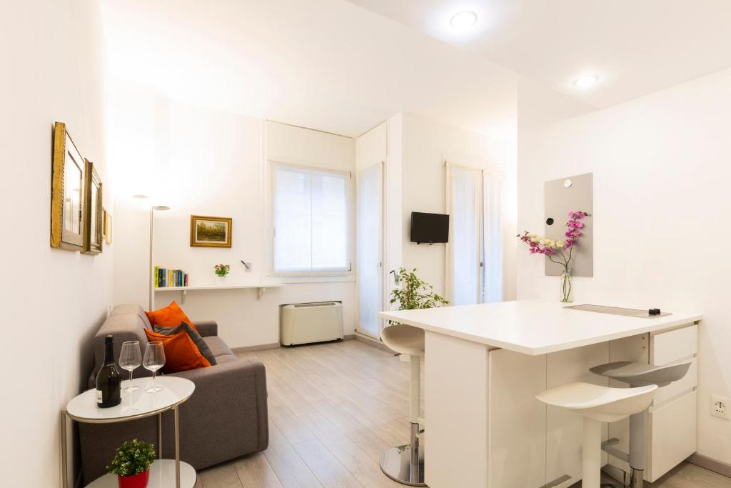 a white living room with a couch and a table at Queen of Brera - San Marco 1 in Milan