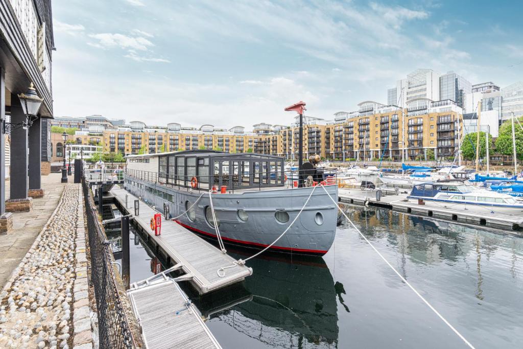 a boat docked at a marina in a city at Stunning houseboat with sauna in London