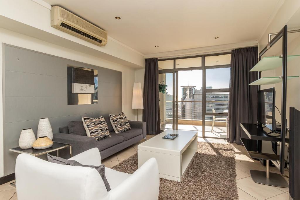 a living room with a couch and a television at ITC Icon Two bedroom Apartment with lovely balcony in Cape Town