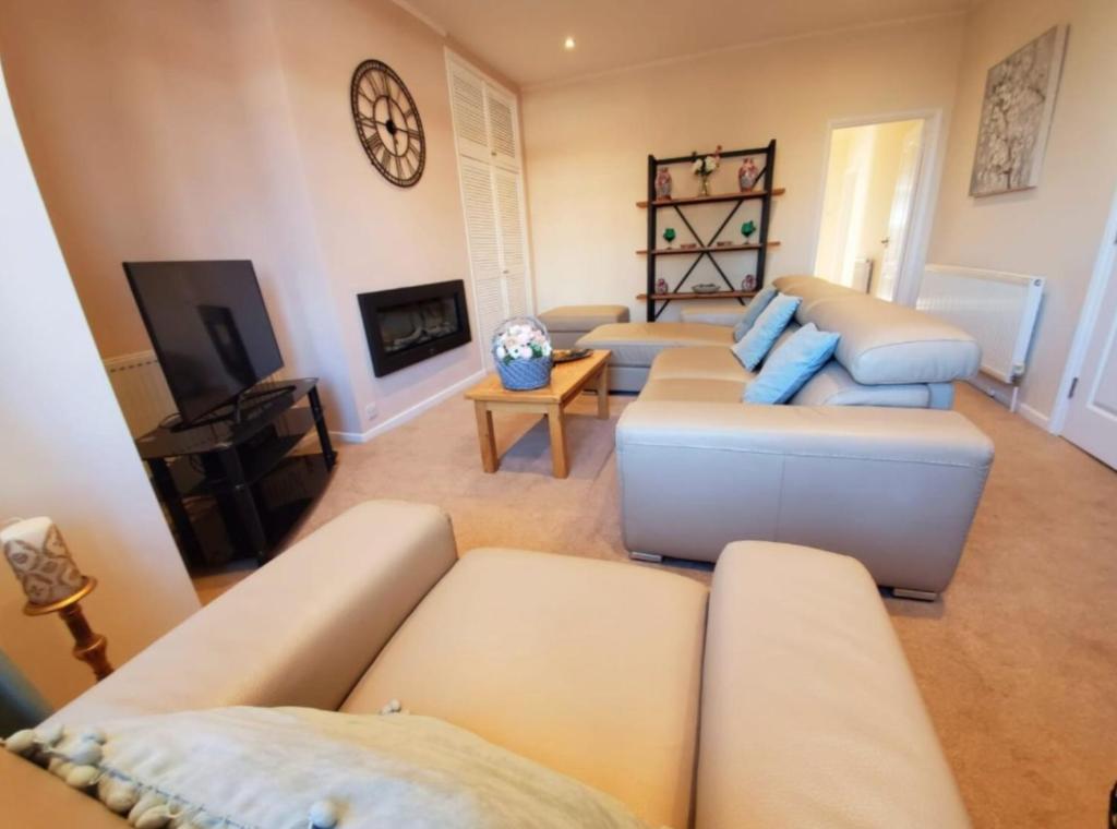 a living room with two couches and a tv at Belle-Vue Apartments in Hunstanton