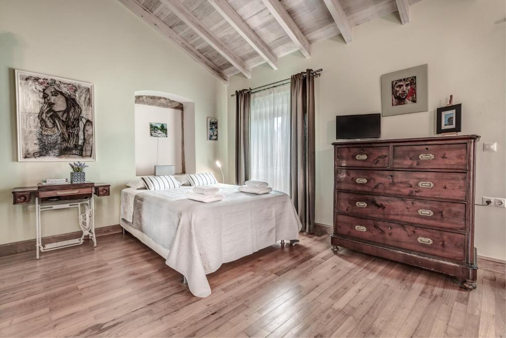 a bedroom with a large bed and a dresser at Corfu House of Art Suite - Anemomylos in Anemómylos