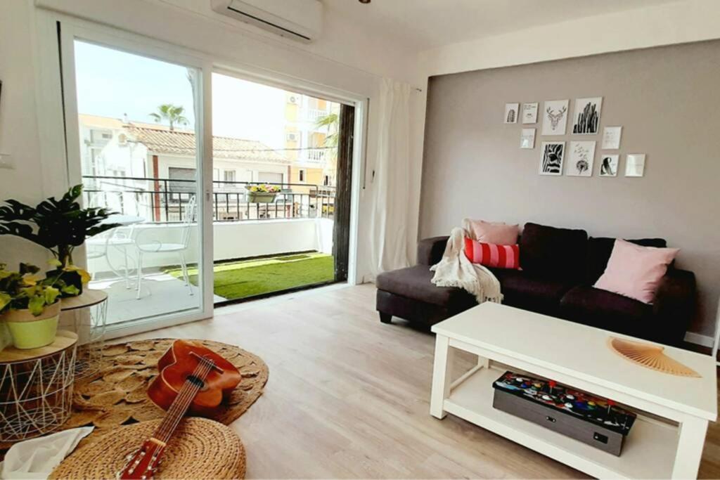 un soggiorno con divano e chitarra di Acogedor y luminoso apartamento con vistas al mar a Rincón de la Victoria