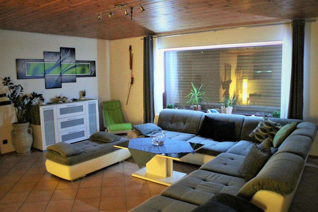 sala de estar con sofá y mesa en Die Panorama-Wohnung-im-Grünem, en Allensbach