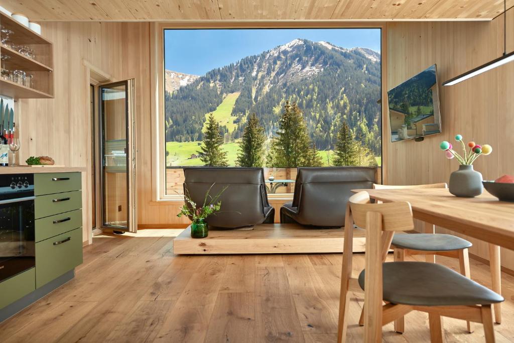 a kitchen with a table and a view of a mountain at Spycher - Chalets für 2 in Riezlern