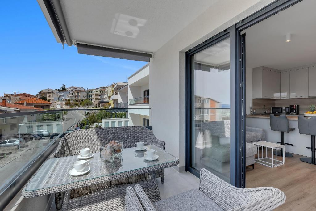 a living room with a table and chairs on a balcony at Apartman Elite in Makarska